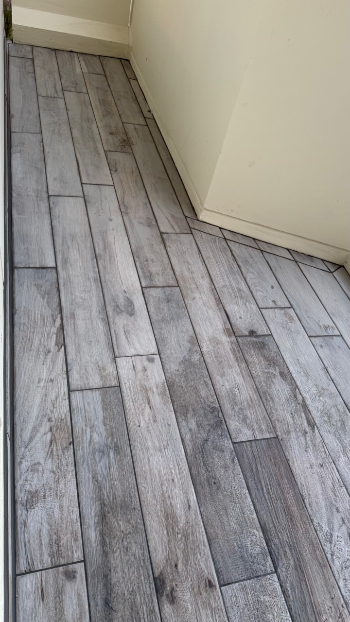 Carrelage effet bois posé sur toute la longueur visible d’un balcon.