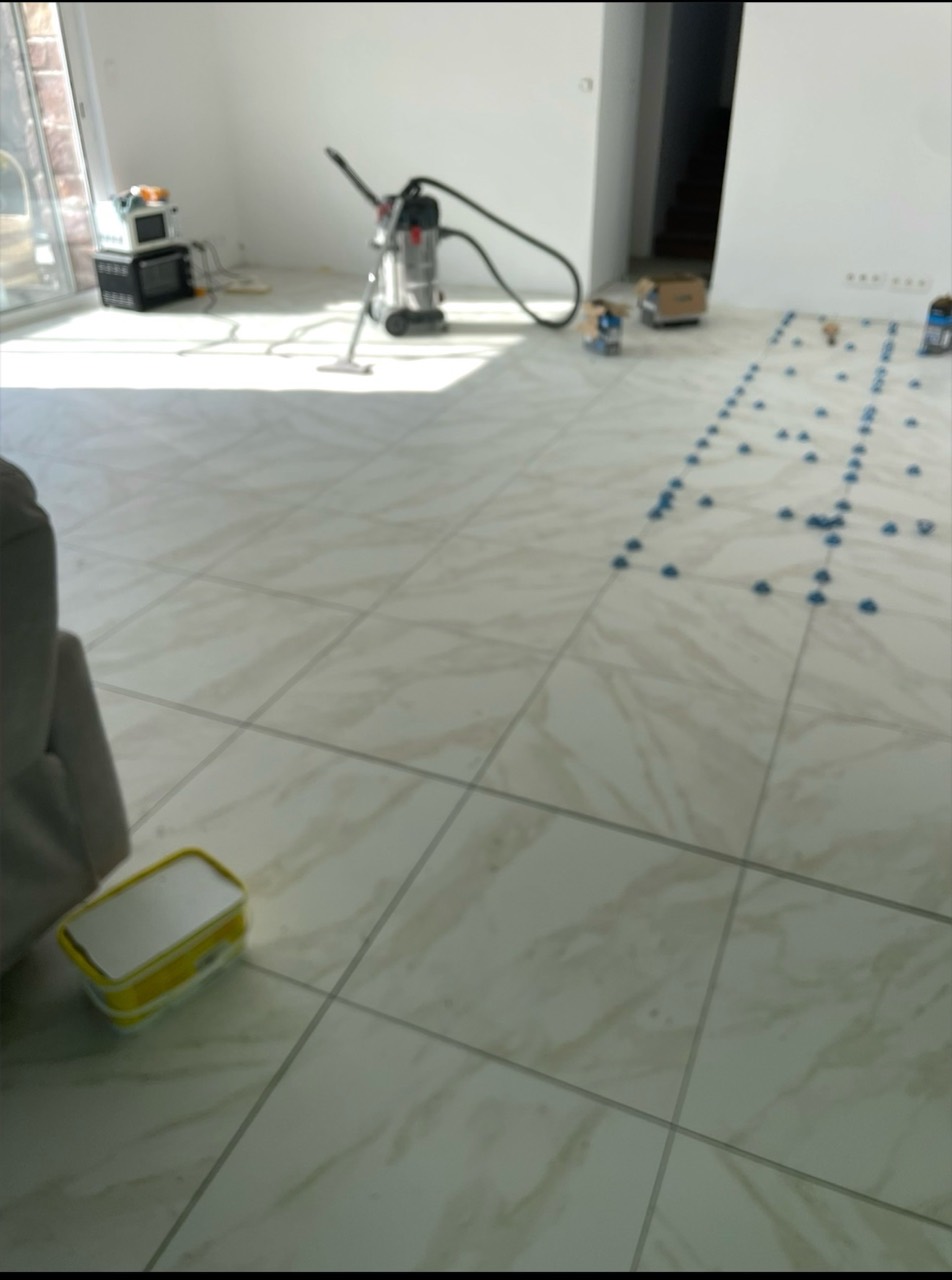 Carrelage grand format posé dans une pièce de vie encore en chantier.