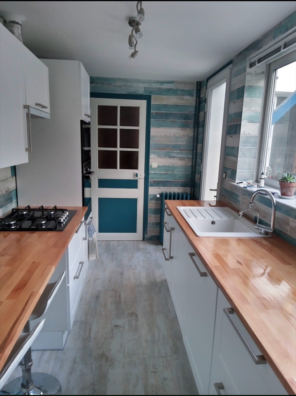 Vue d’ensemble d’une cuisine rénovée avec plans de travail en bois.