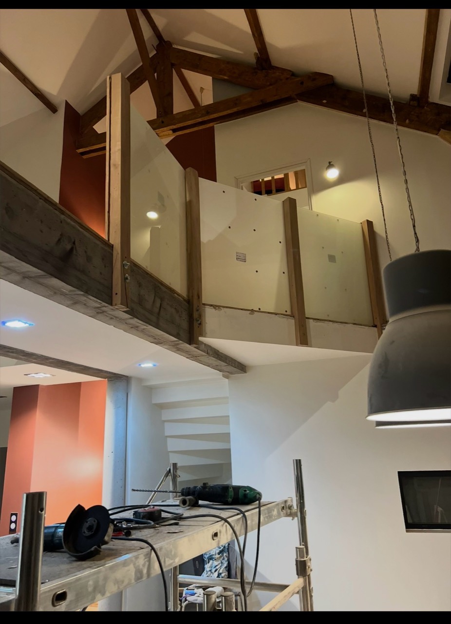 Aménagement intérieur avec mezzanine, cloison et garde-corps en cours de réalisation.
