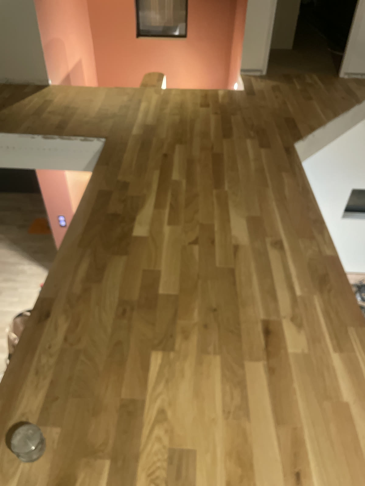 Palier intérieur recouvert d’un revêtement de sol aspect bois autour de la cage d’escalier.