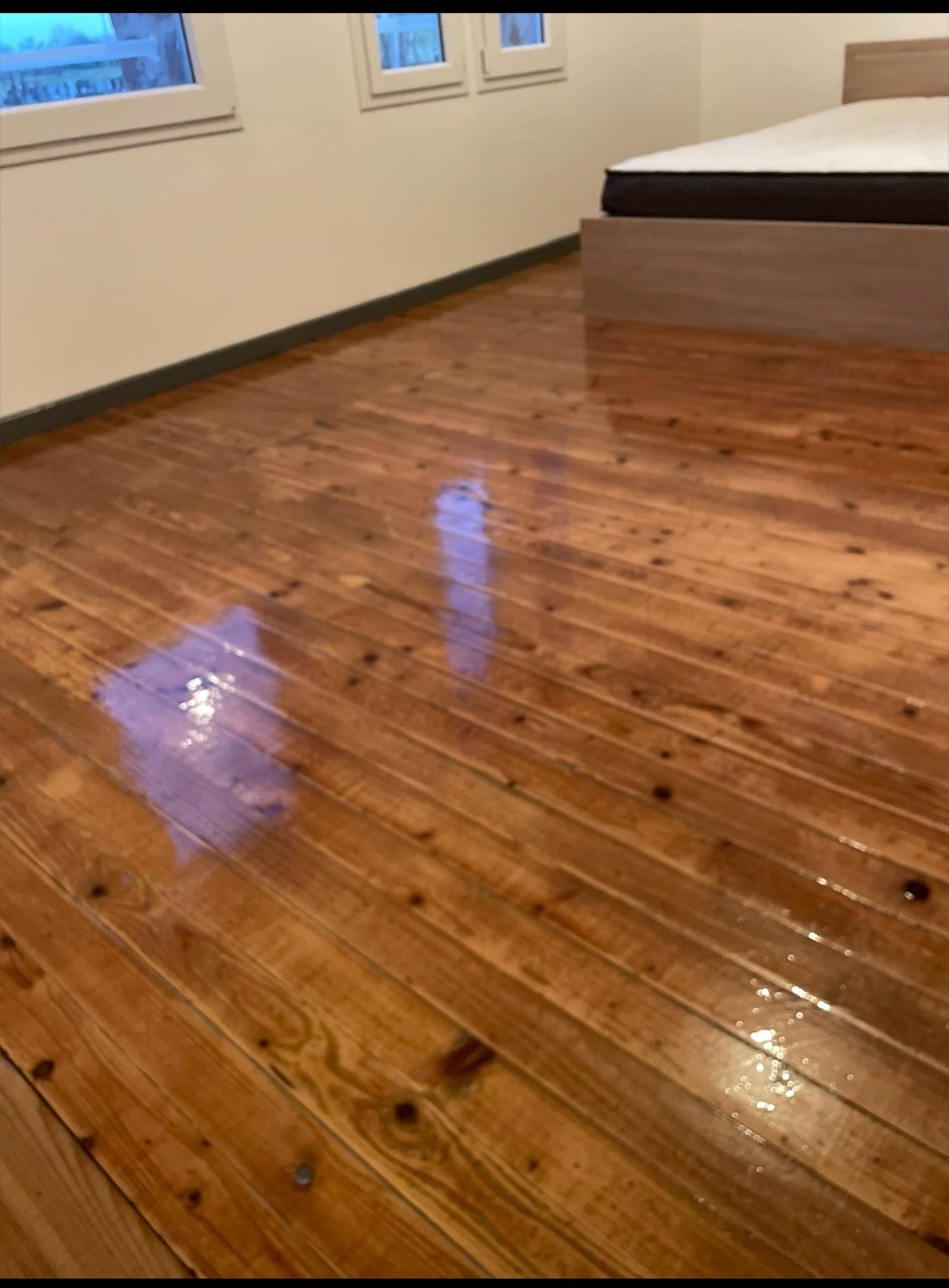 Parquet en bois avec une finition brillante dans une chambre.