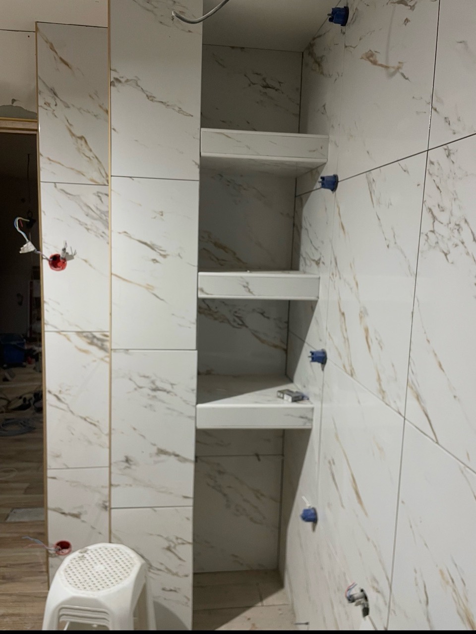 Création de niches carrelées dans une salle de bain en cours de rénovation.